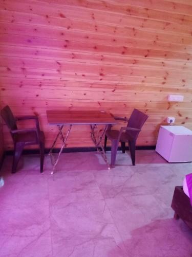a ping pong table in a room with two chairs at The Cool Huts in Mandrem