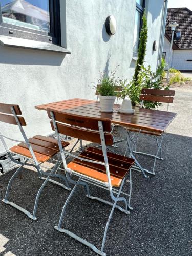 uma mesa de madeira e duas cadeiras sentadas ao lado de um edifício em Schröders Gästehaus em Langstedt