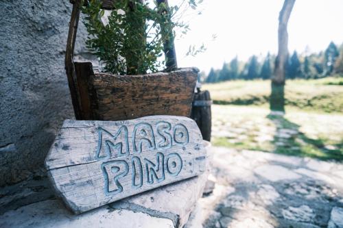 a sign that says mason runo sitting next to a plant at Chalet Maso Pino in Castello Tesino