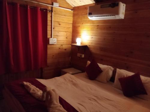 um quarto com uma cama num quarto com uma cortina vermelha em The Cool Huts em Mandrem