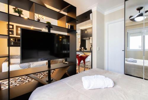 a bedroom with a large flat screen tv on a wall at 1606 - Luxo e Conforto na Cidade Maia in Guarulhos