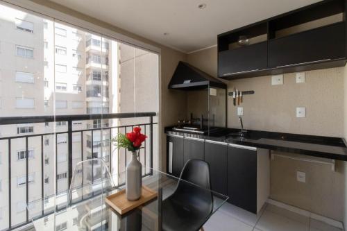 a kitchen with a glass table with a vase of flowers at 1606 - Luxo e Conforto na Cidade Maia in Guarulhos
