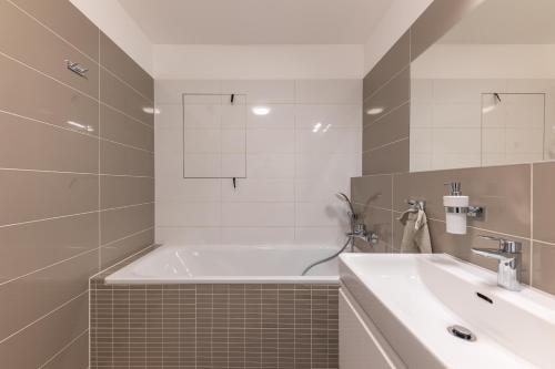 y baño con bañera y lavamanos. en NFS - Národný futbalový štadión - Apartman en Bratislava