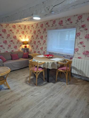 a living room with a table and chairs and a couch at Les Bruyères du Mont in Céaux