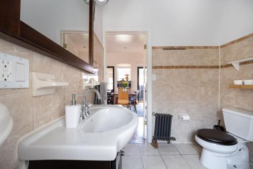 a bathroom with a white sink and a toilet at East Village Townhouse in New York