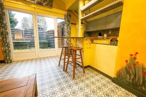 a yellow kitchen with a counter and a stool at #M1 La maisonnette des 3 ponts Terrace in Saint-Égrève