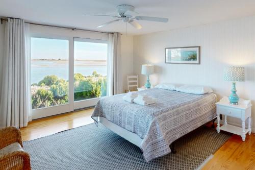 Un dormitorio con una cama y una ventana grande. en West Dennis Dockside, en West Dennis