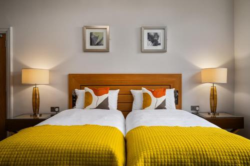 a bedroom with two beds with yellow and white pillows at Elephant and Castle in Wakefield