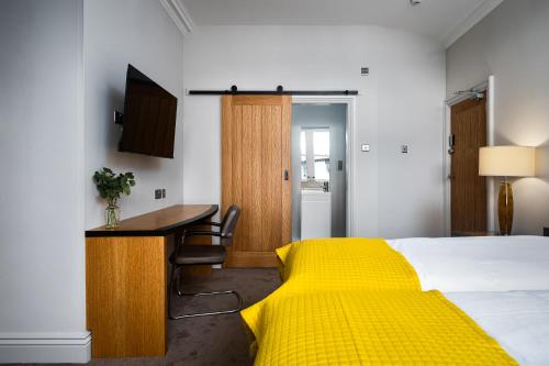 a bedroom with a yellow bed and a desk at Elephant and Castle in Wakefield