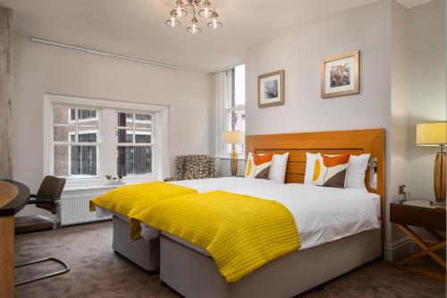 a bedroom with a large bed with a yellow blanket at Elephant and Castle in Wakefield