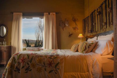 a bedroom with a large bed with a window at Posada Punta de Piedra in La Cumbre
