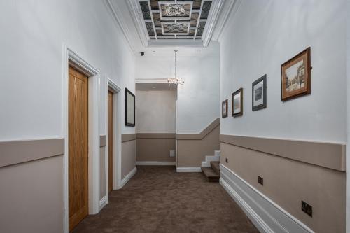 a hallway with a door and pictures on the walls at Elephant and Castle in Wakefield
