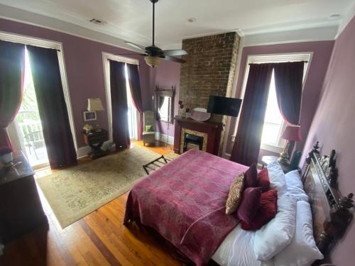 a bedroom with a large bed and a fireplace at The Dragonfly Guest House in New Orleans