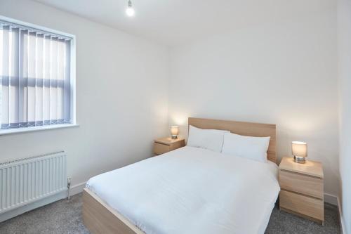 a bedroom with a white bed and two night stands at Host & Stay - Loftus Apartments in Loftus