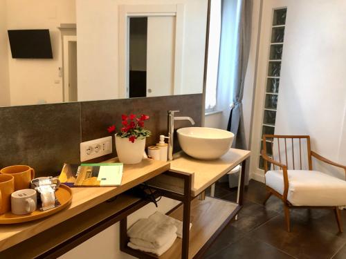 ein Badezimmer mit einer Theke mit einem Waschbecken und einem Spiegel in der Unterkunft DIMOR'A' ROOMS in Pitigliano