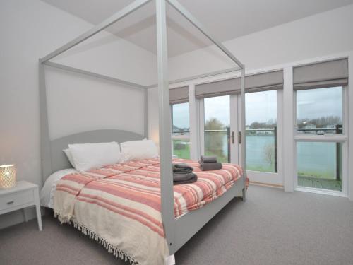 um quarto com uma cama de dossel branca e uma janela em 4 bed in South Cerney 72676 em South Cerney