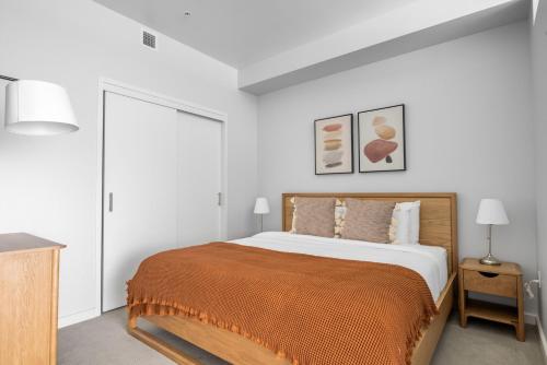 een witte slaapkamer met een bed met een oranje deken bij Soma 1br w pool yoga spa nr station bars SFO-1476 in San Francisco