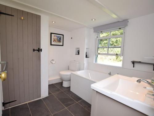 a bathroom with a tub and a toilet and a sink at 3 bed in Perranporth 57204 in Perranzabuloe