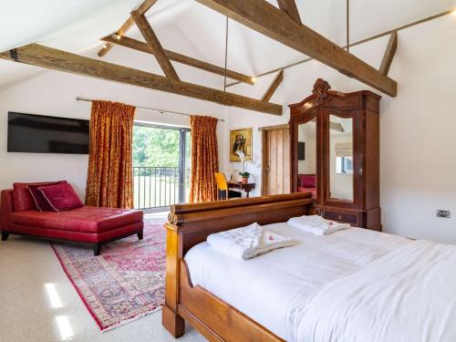 een slaapkamer met een groot bed en een rode stoel bij 2 bed in Lound 82801 in Hopton on Sea