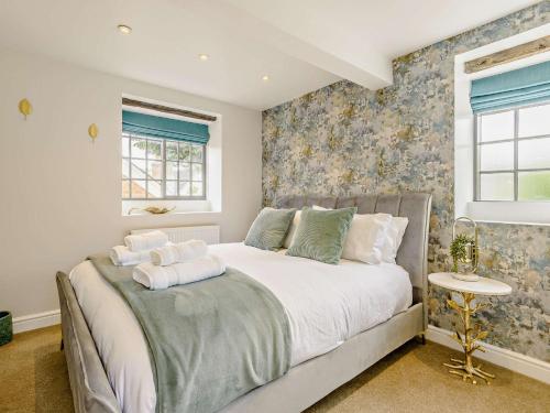 a bedroom with a large bed with floral wallpaper at 3 bed in Wirksworth 83082 in Wirksworth