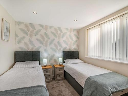 2 Einzelbetten in einem Zimmer mit Fenster in der Unterkunft 2 bed property in Howden 86817 in Scalby