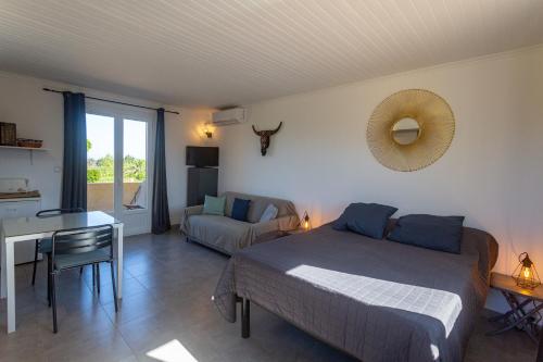 een slaapkamer met een bed, een tafel en een bureau bij Studio dans résidence avec piscine in Calvi