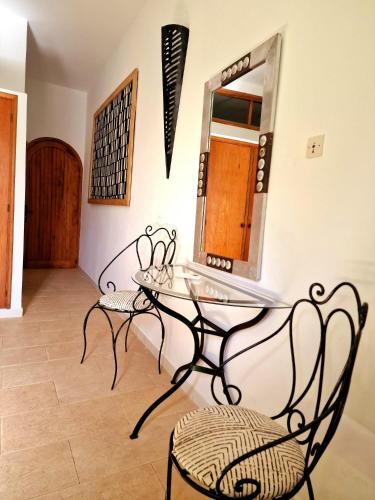 a glass table and chairs in a room with a mirror at Ginger Villa Somone in Somone
