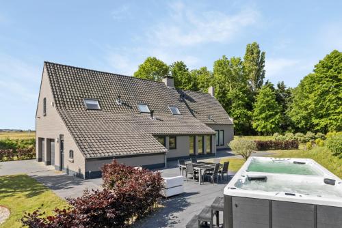 an exterior view of a house with a hot tub at Landgoed Hermitage - Villa Euphoria - XXL Zwemspa - Max 10 personen in Ouddorp
