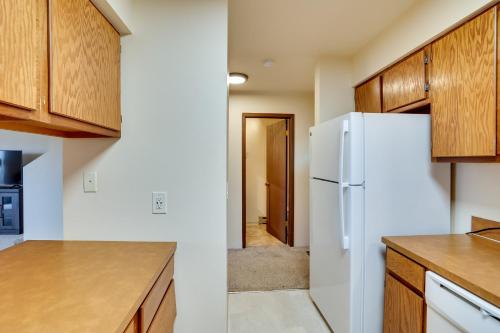 a kitchen with a white refrigerator and wooden cabinets at Lewiston Vacation Rental with Nearby River Access! in Lewiston