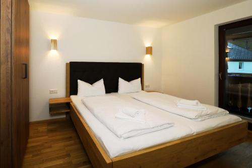 um quarto com uma cama com duas toalhas brancas em Tannenhof Fischbach - Fewo 3 "Bachforelle" - Schluchsee, 1 Schlafzimmer em Schluchsee