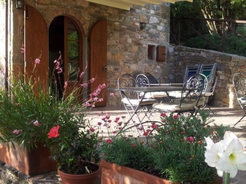 a patio with a table and chairs and flowers at Fattoria Poggerino in Radda in Chianti