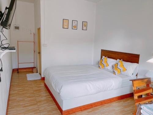 a bedroom with a large white bed with yellow pillows at Muji House Resort in Non Sang