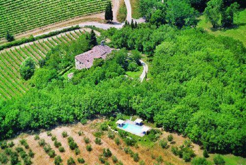 an aerial view of a house in a field with a pool at Fattoria Poggerino in Radda in Chianti