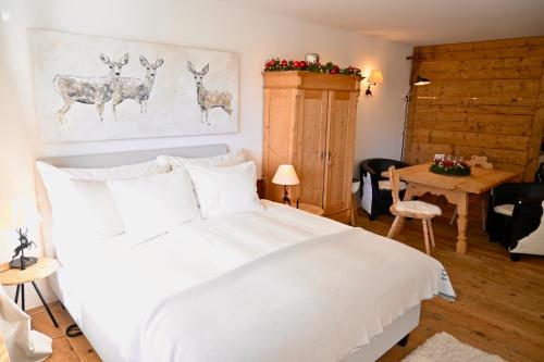 a bedroom with a white bed with deer paintings on the wall at Residence Au Reduit Sankt Moritz in St. Moritz