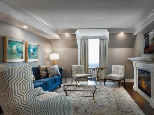 a living room with a blue couch and a fireplace at Chateau Vaudreuil in Vaudreuil-Dorion