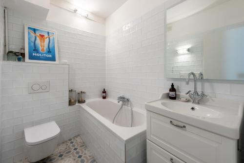 ein weißes Badezimmer mit einer Badewanne und einem Waschbecken in der Unterkunft Alma - Charmant apt 2 chambres in Lyon