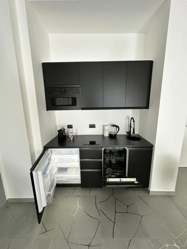 a kitchen with black cabinets and a counter top at Casa Genovesi - vicino Porta Nuova F.S. in Turin