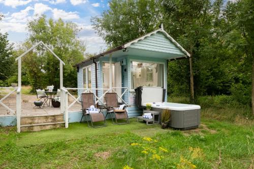 a small blue house with a bath tub in the yard at Art Studio - Connect to Nature in the Hot Tub at Cosy Studio in Blandford Forum