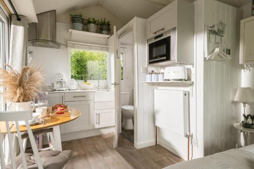 a small kitchen with a table and a sink at Art Studio - Connect to Nature in the Hot Tub at Cosy Studio in Blandford Forum