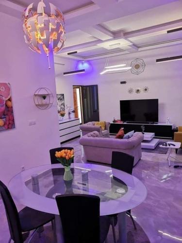 uma sala de estar com uma mesa e um sofá em Appartement meublé em Cotonou