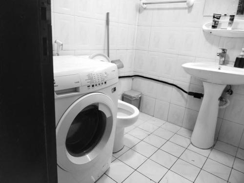 uma casa de banho com uma máquina de lavar roupa e um lavatório em Sharaf DG Partition Private room 40 flat 03# em Dubai