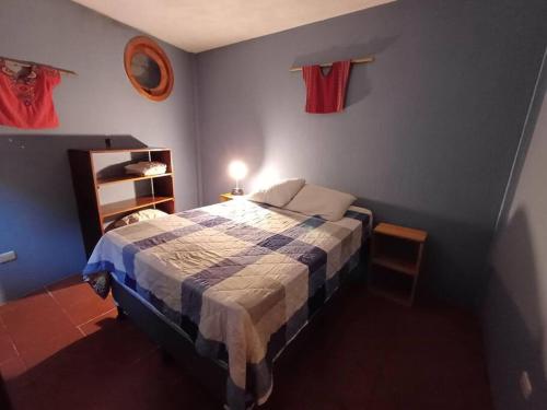 1 dormitorio con 1 cama con pared azul en Little House near Main Market, en Panajachel