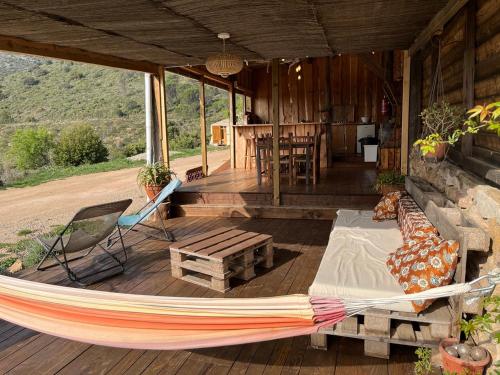 a hammock on a porch of a house at Yourte Nature / Gîte Saint Roch in Tuchan