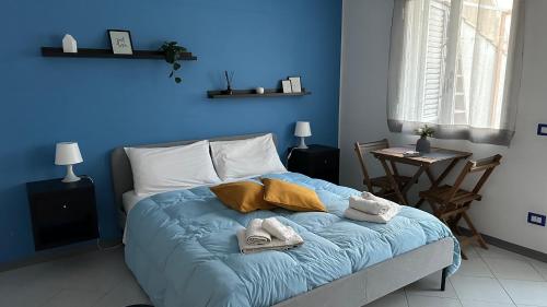 a blue bedroom with a bed with towels on it at Appartamento Vittoria in Vittoria