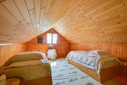 1 dormitorio con 2 camas en una cabaña de madera en Warm and Cozy Clayton Cabin Near St Lawrence River!, en Clayton