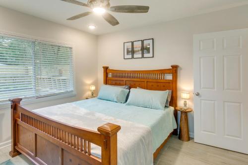 a bedroom with a wooden bed and a ceiling fan at Bright Jekyll Island Home with Deck Less Than 1 Mi to Beach in Jekyll Island