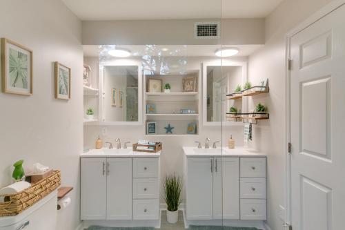 a white bathroom with two sinks and a mirror at Bright Jekyll Island Home with Deck Less Than 1 Mi to Beach in Jekyll Island