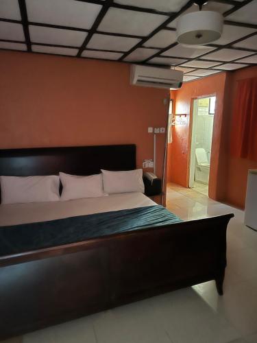 1 dormitorio con 1 cama grande y pared de color naranja en STONE CASTLE HOTEL, en Freetown