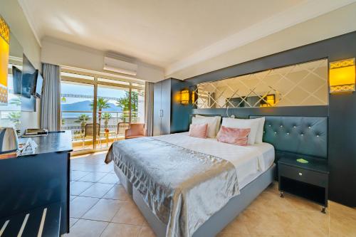 a bedroom with a large bed and a balcony at Prime Beach Hotel Ex Ideal Prime Beach in Marmaris