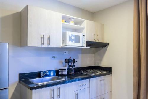 a kitchen with a sink and a microwave at Apartamento Tranvía 210 in Medellín